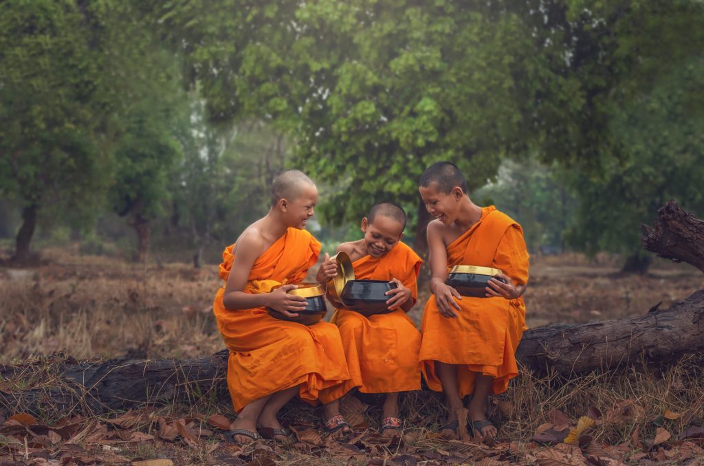 Three Neophyte monk are talking and holding the monk's alms bowl