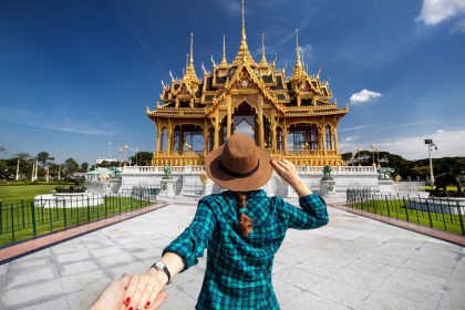 Woman in hat and green checked shirt leading man to the Ananta Samakhom Throne Hall in Thai Royal Dusit Palace, Bangkok, Thailand